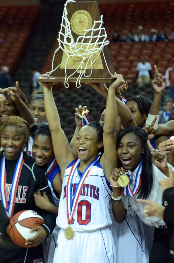 Senior Morgan Bolton holds up the State Championship trophy in front of her team on the floor of UT Austins Frank Erwin Center Saturday. The team claimed their first State Championship since 2003. (Abigail Padgett photo)
