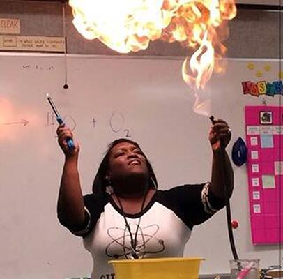 Mrs. Shelly Hinson-Cooper watches as her experiment lights up the air in her science room during a Halloween show for her students. (Kennedy Stidham photo)