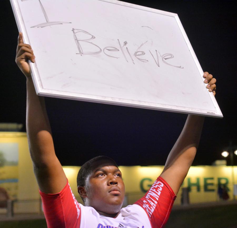 Nearing the end of the fourth quarter with the Panthers down by two scores, a player on the sidelines holds up a white board to encourage the team. (Karla Estrada Photo)