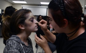 The cosmetology student  transformimg one of the actors into a zombie for the film.