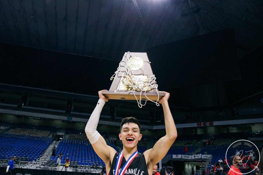 Senior Juan Reyna holds up the UIL 6A Championship trophy.
